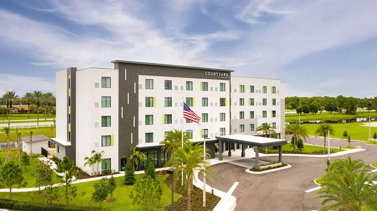 5 story hotel in portico entrance amoung palm trees