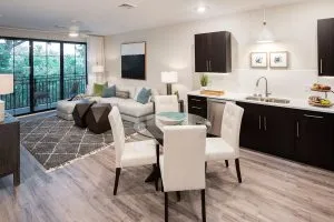 Apartment with kitchen with small table and chairs and living room with sliding glass doors
