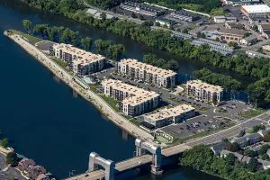 aera view of apartment building on long pointed piece of land next to split in river
